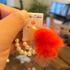 Fashion pearl and pom earings.